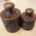 Vintage Metal Weights1Kg & 50dkg 
Measures 3 1/4" & 2 1/4" tall